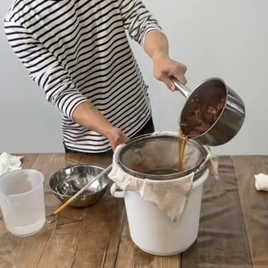 7.2つのざるの間にこし布を挟んでバケツにのせ、玉ねぎの煮汁を注いで濾す。